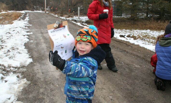 Child holding clipboard in winter