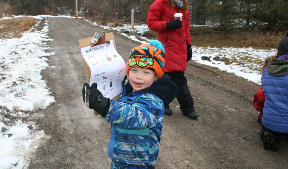 Child holding clipboard in winter